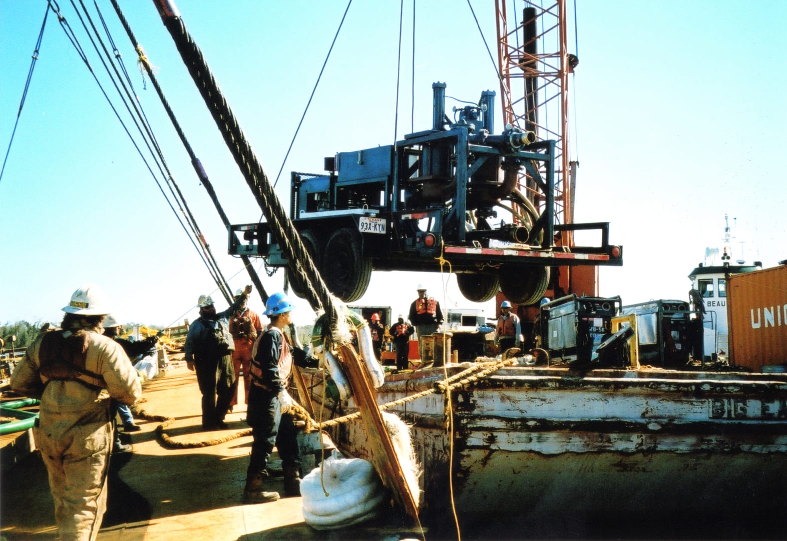 A crane lifting a truck off the ground.