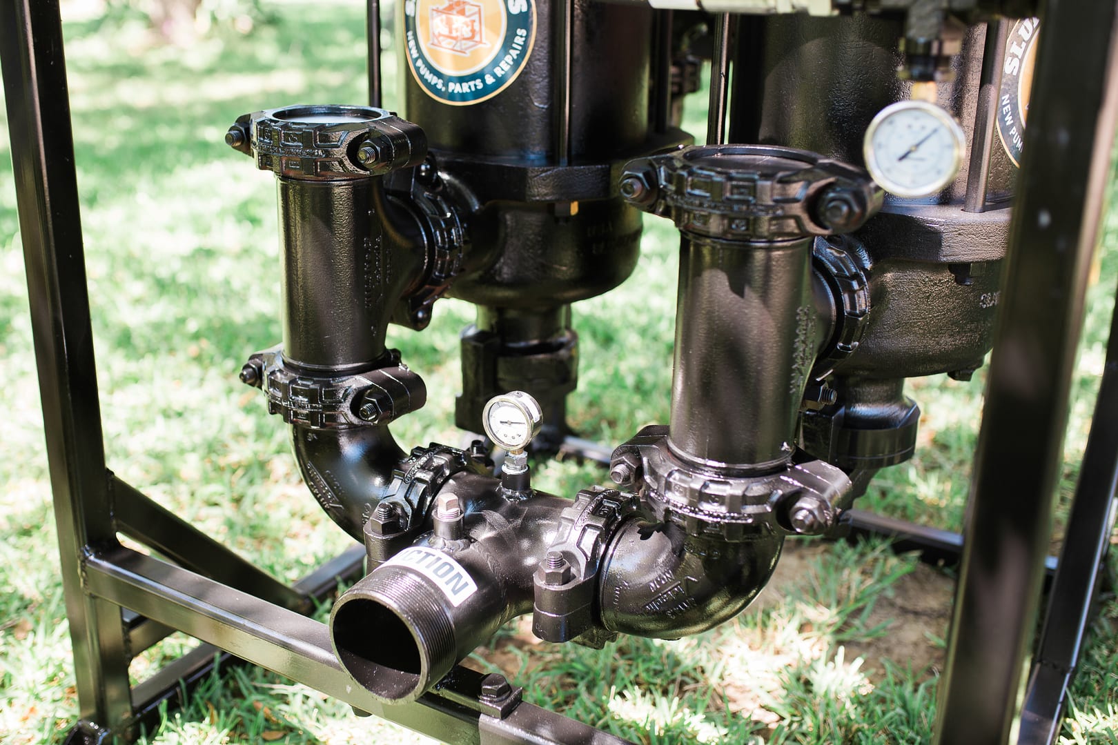 A black pipe sitting on top of grass.